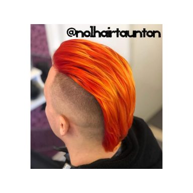 A close-up of a stylish haircut featuring bright orange slicked-back hair.